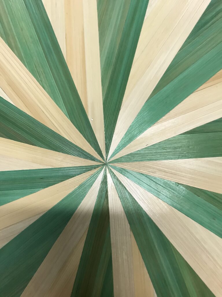 centre d'un motif soleil bicolore en marqueterie de paille