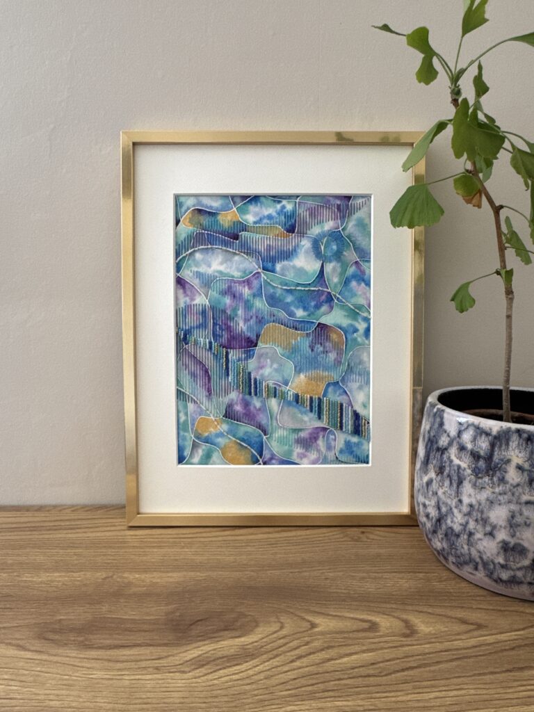 oeuvre en aquarelle brodée avec coton et perles dans les tons bleus et violets avec une pointe de doré